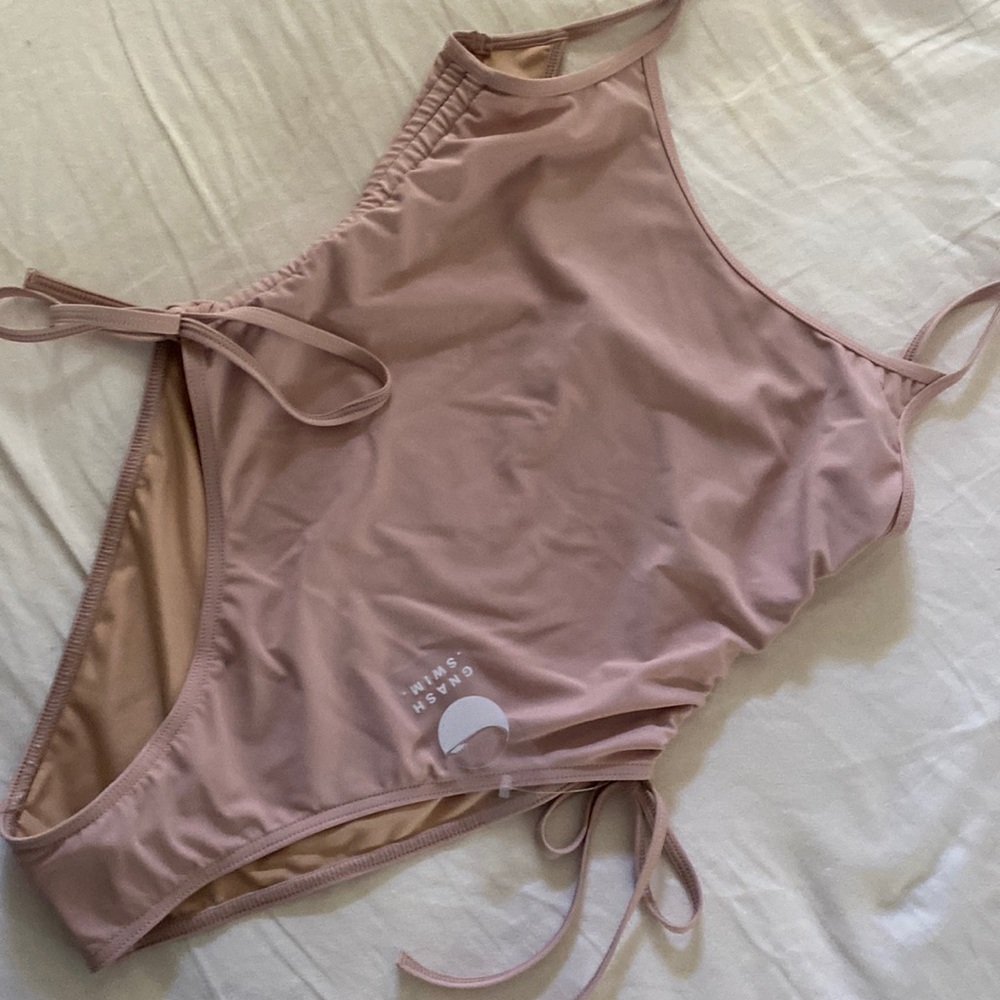 One piece suit ties and cinches at sides.